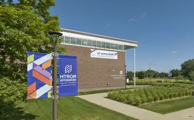 colorful banner with nhcc logo and a banner on a building with the word welcome